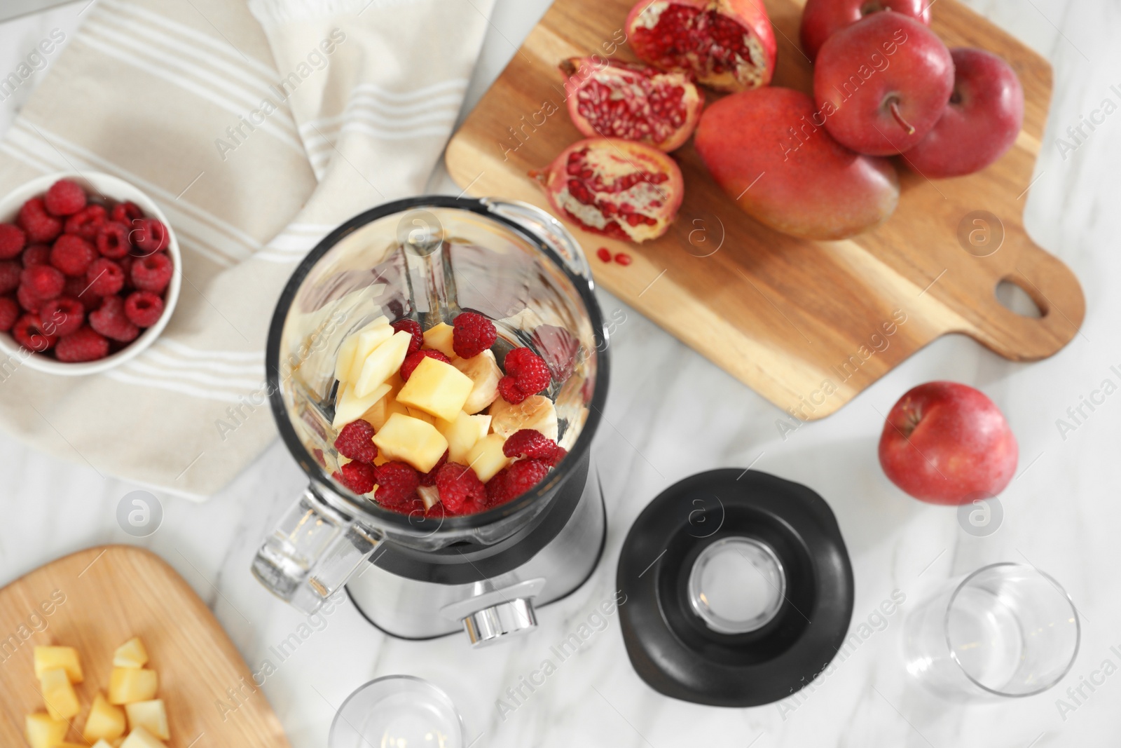 Photo of Blender with smoothie ingredients on white marble table in kitchen, above view