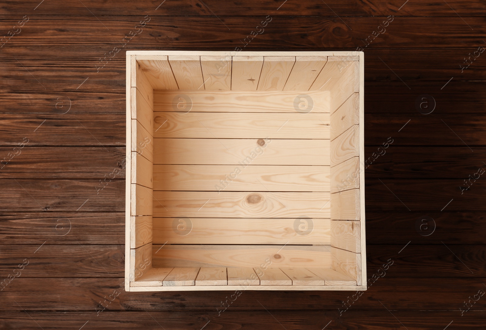 Photo of Open empty wooden crate on color background, top view