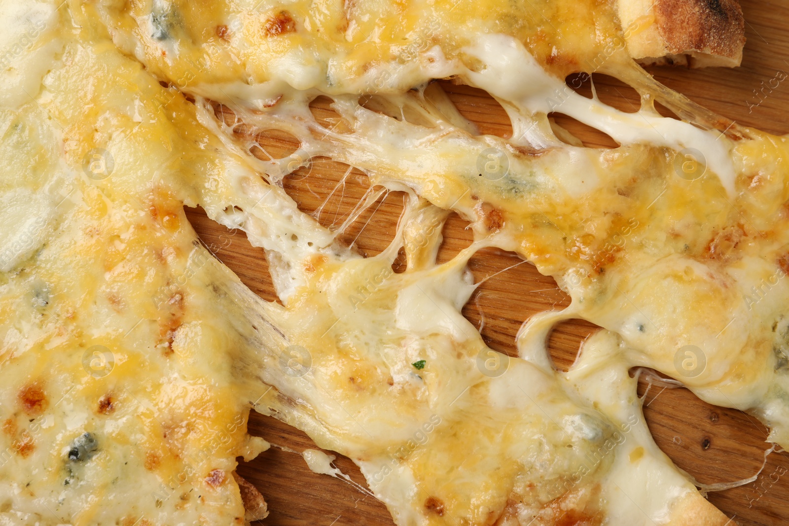 Photo of Delicious cut cheese pizza on wooden board, top view