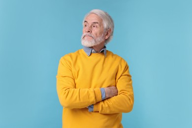 Portrait of stylish grandpa on light blue background