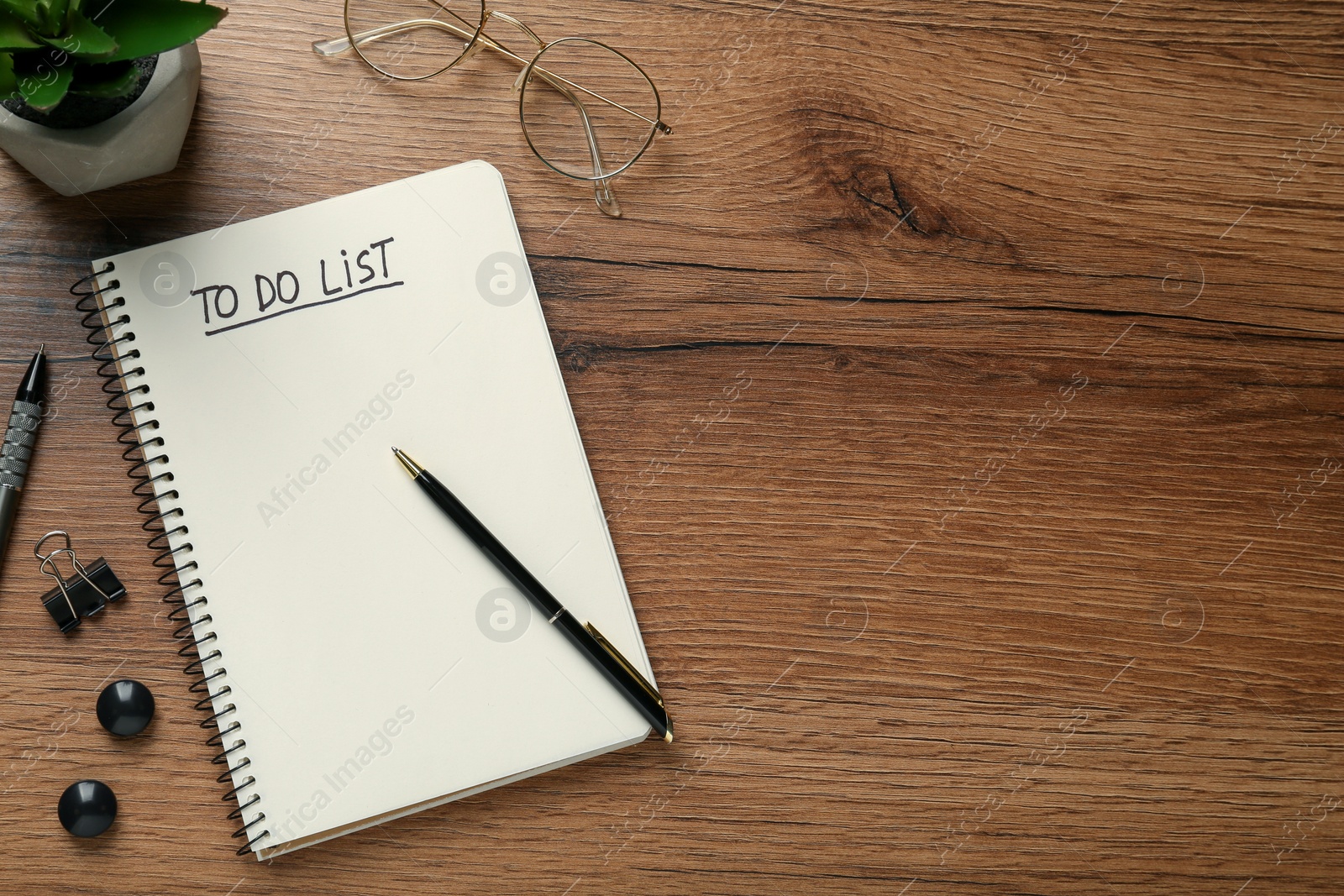 Photo of Flat lay composition with unfilled To Do list in notebook and glasses on wooden table, space for text