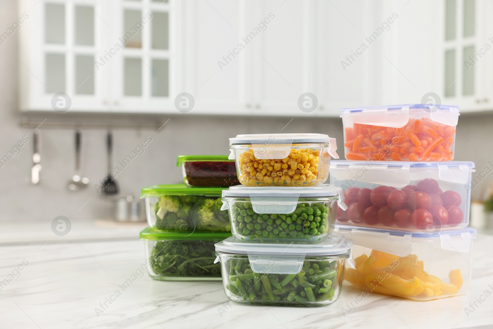 Photo of Glass and plastic containers with different fresh products on white marble table in kitchen, space for text. Food storage