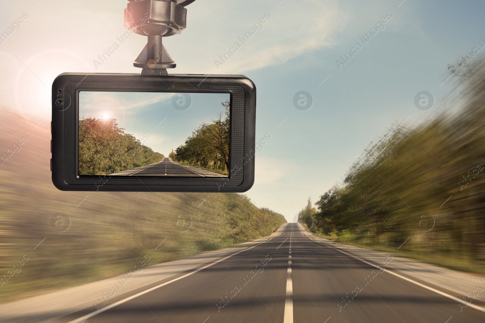 Image of Modern dashboard camera mounted in car, view of road during driving