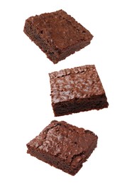 Slices of delicious chocolate brownie flying on white background