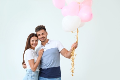 Photo of Young couple with air balloons at home. Celebration of Saint Valentine's Day