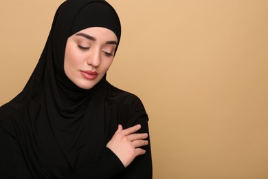 Photo of Portrait of Muslim woman in hijab on beige background. Space for text