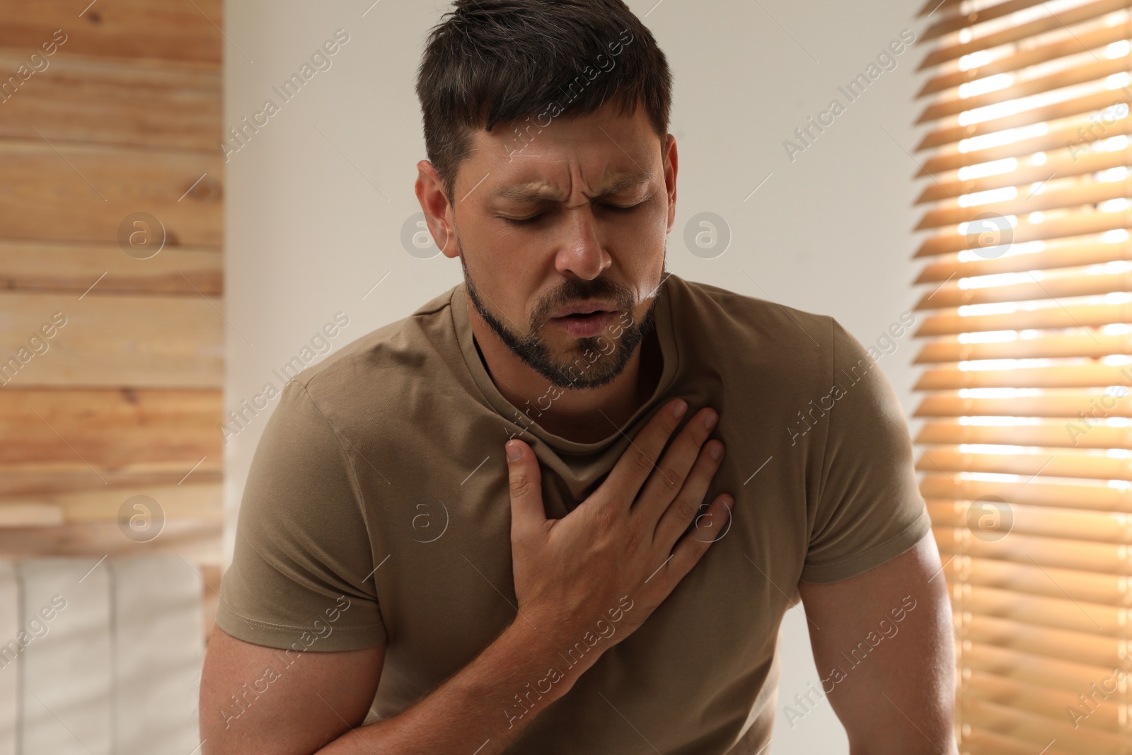 Photo of Man suffering from pain during breathing at home