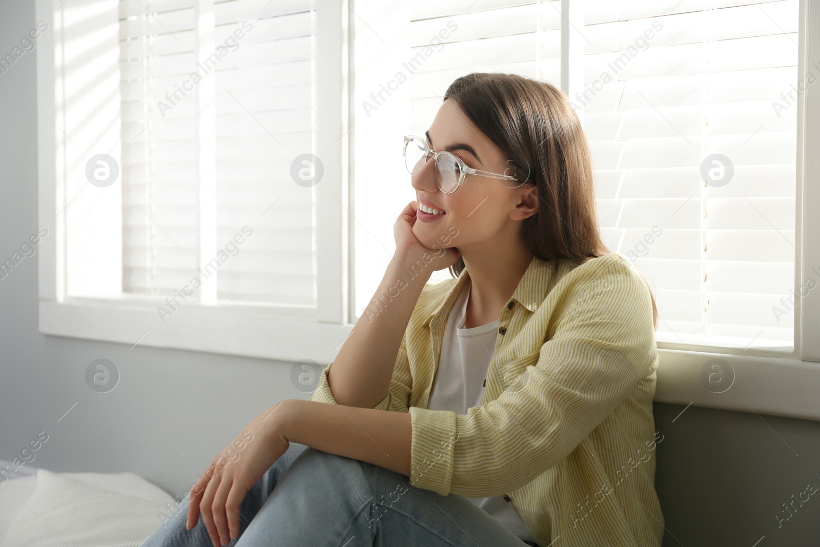 Photo of Beautiful young woman near window at home