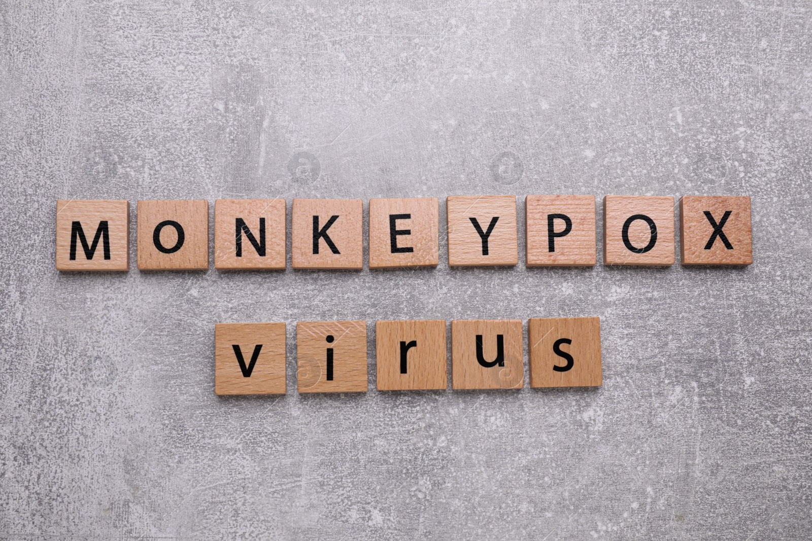 Photo of Words Monkeypox Virus made of wooden squares with letters on light grey background, top view