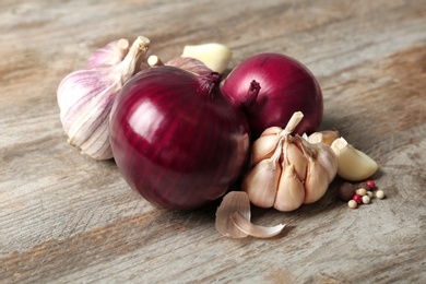Photo of Onions, garlic and spice on wooden background
