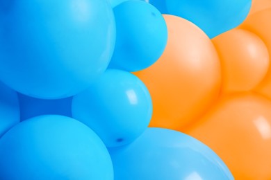 Many orange and light blue balloons as background, closeup. Party decor