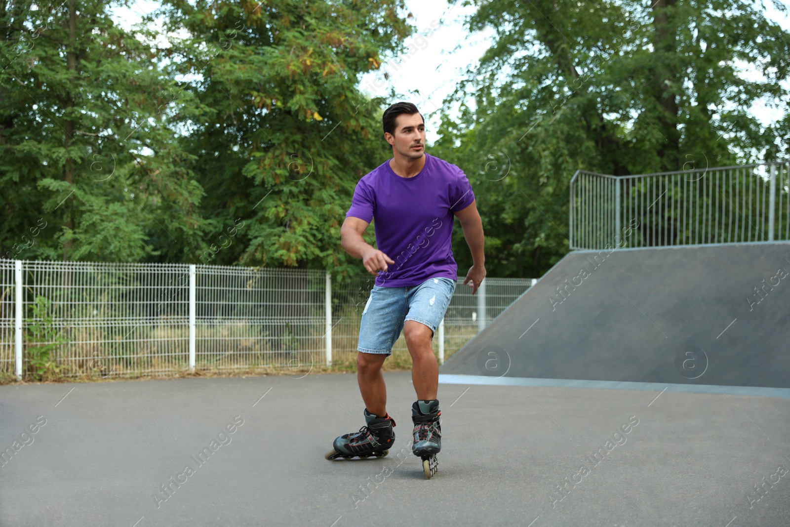 Photo of Handsome young man roller skating in park