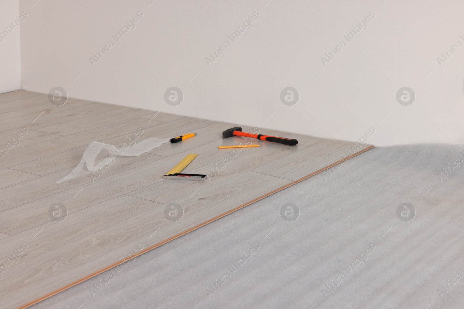 Photo of Repair tools and parquet planks on floor in room prepared for renovation