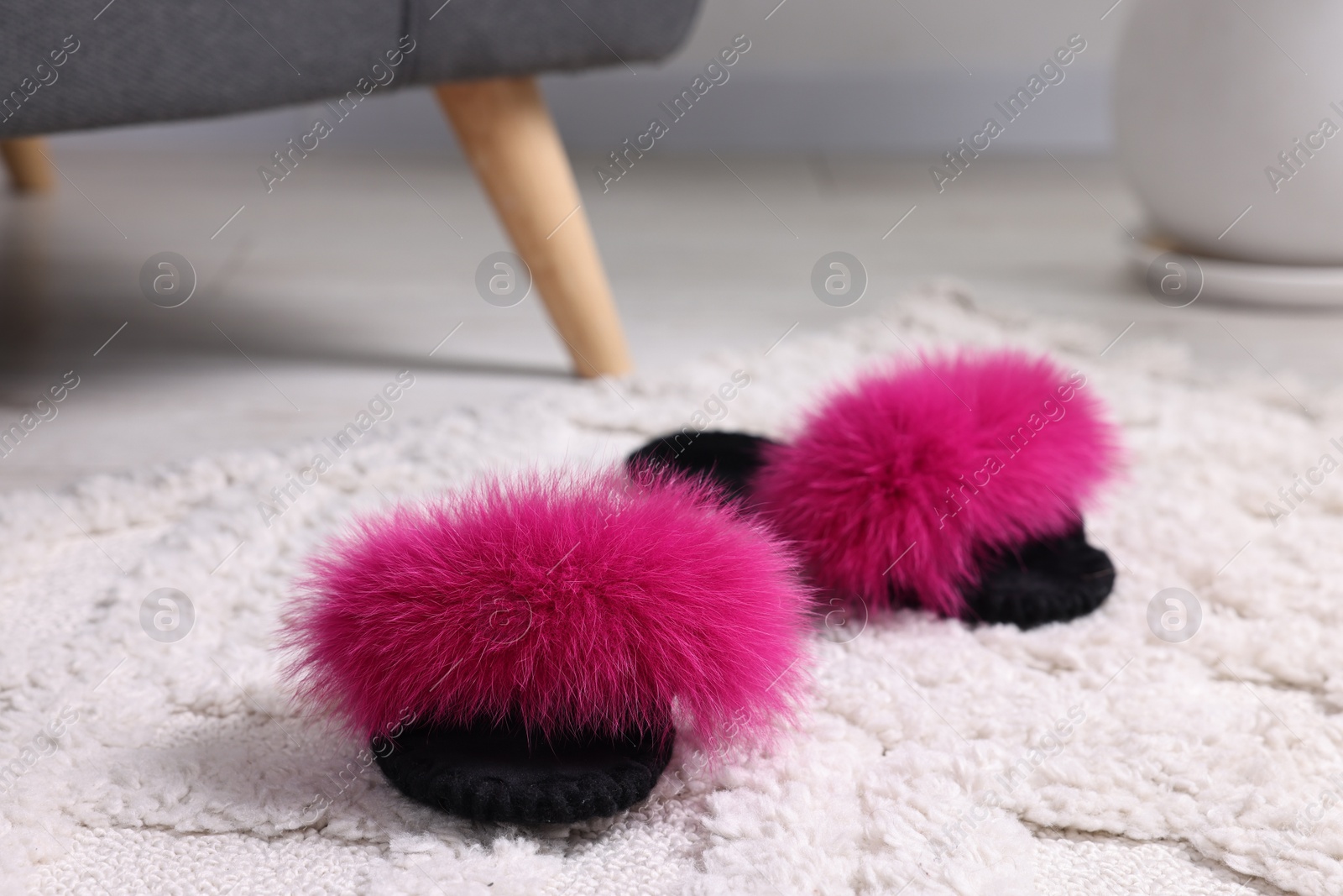 Photo of Colorful soft slippers on light carpet, closeup