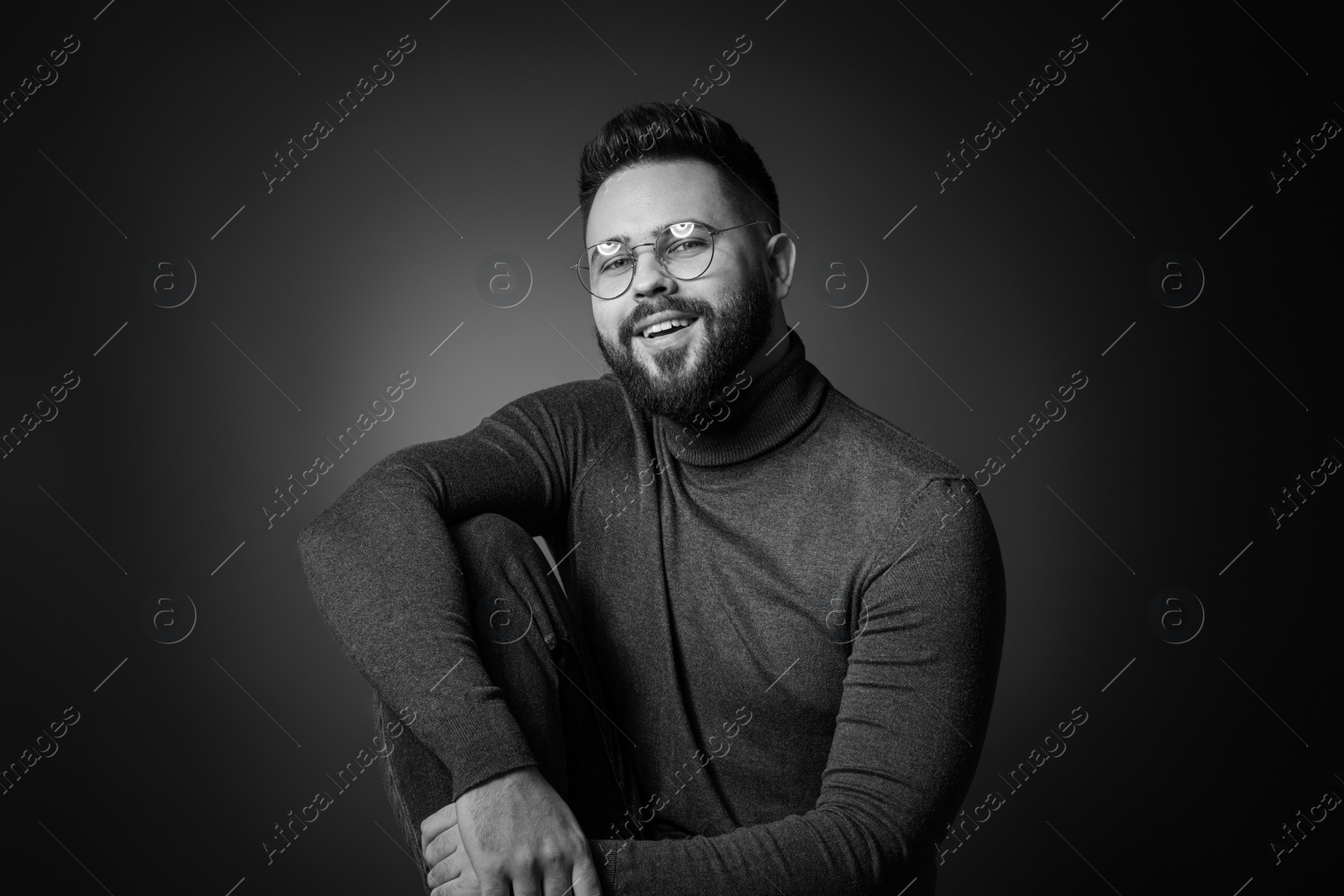 Photo of Portrait of handsome bearded man on dark background. Black and white effect