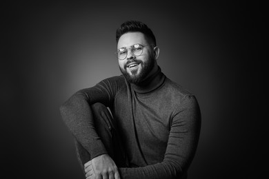 Portrait of handsome bearded man on dark background. Black and white effect