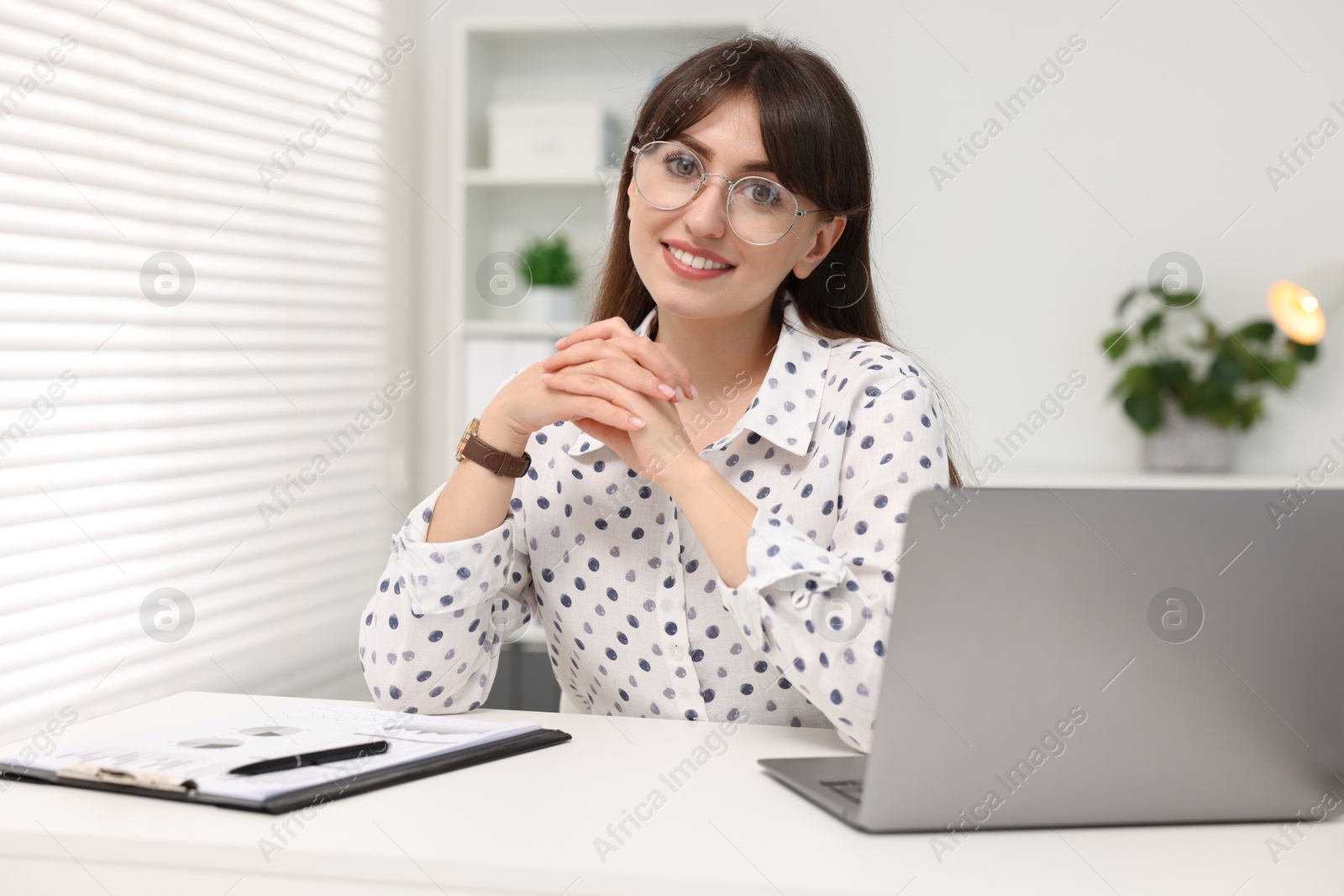 Photo of Portrait of smiling secretary at table in office