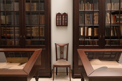 Photo of Library interior with wooden furniture and many books