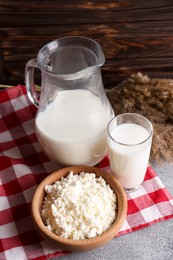 Photo of Tasty fresh milk and cottage cheese on grey table