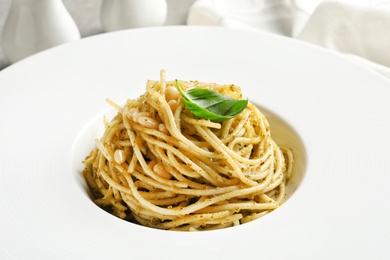 Photo of Delicious basil pesto pasta in plate, closeup