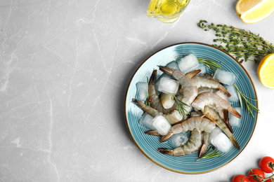 Photo of Flat lay composition with fresh raw shrimps on light grey marble table. Space for text