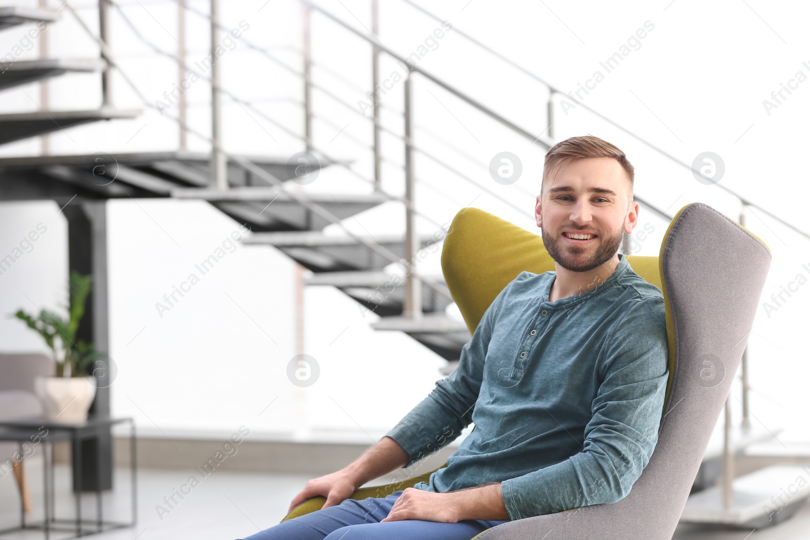 Photo of Portrait of confident young man in armchair