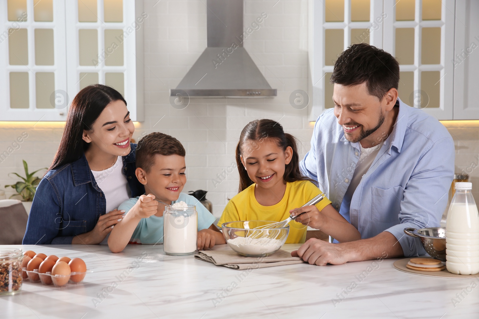 Photo of Happy family cooking together at table in kitchen. Adoption concept