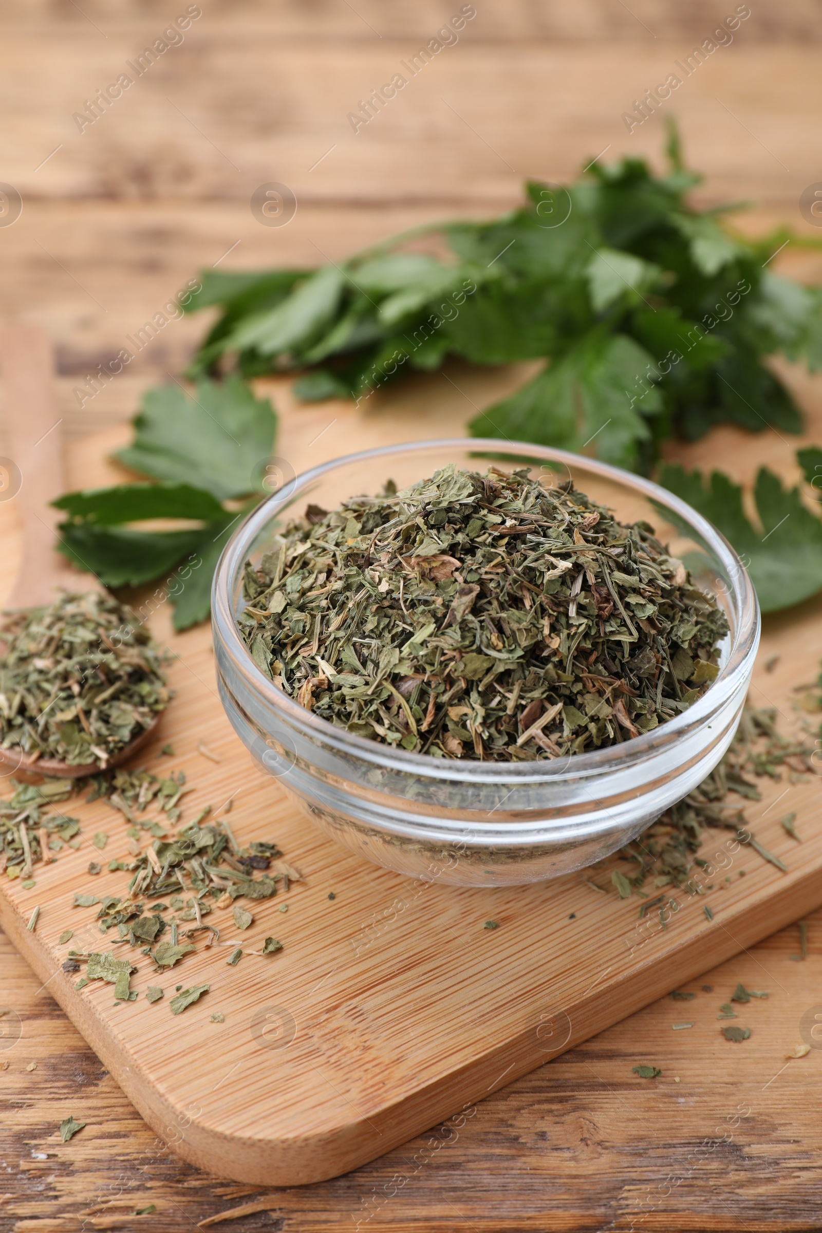 Photo of Dried parsley and fresh leaves on wooden table, closeup