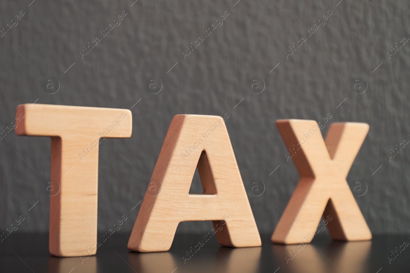 Photo of Word TAX made of letters on table