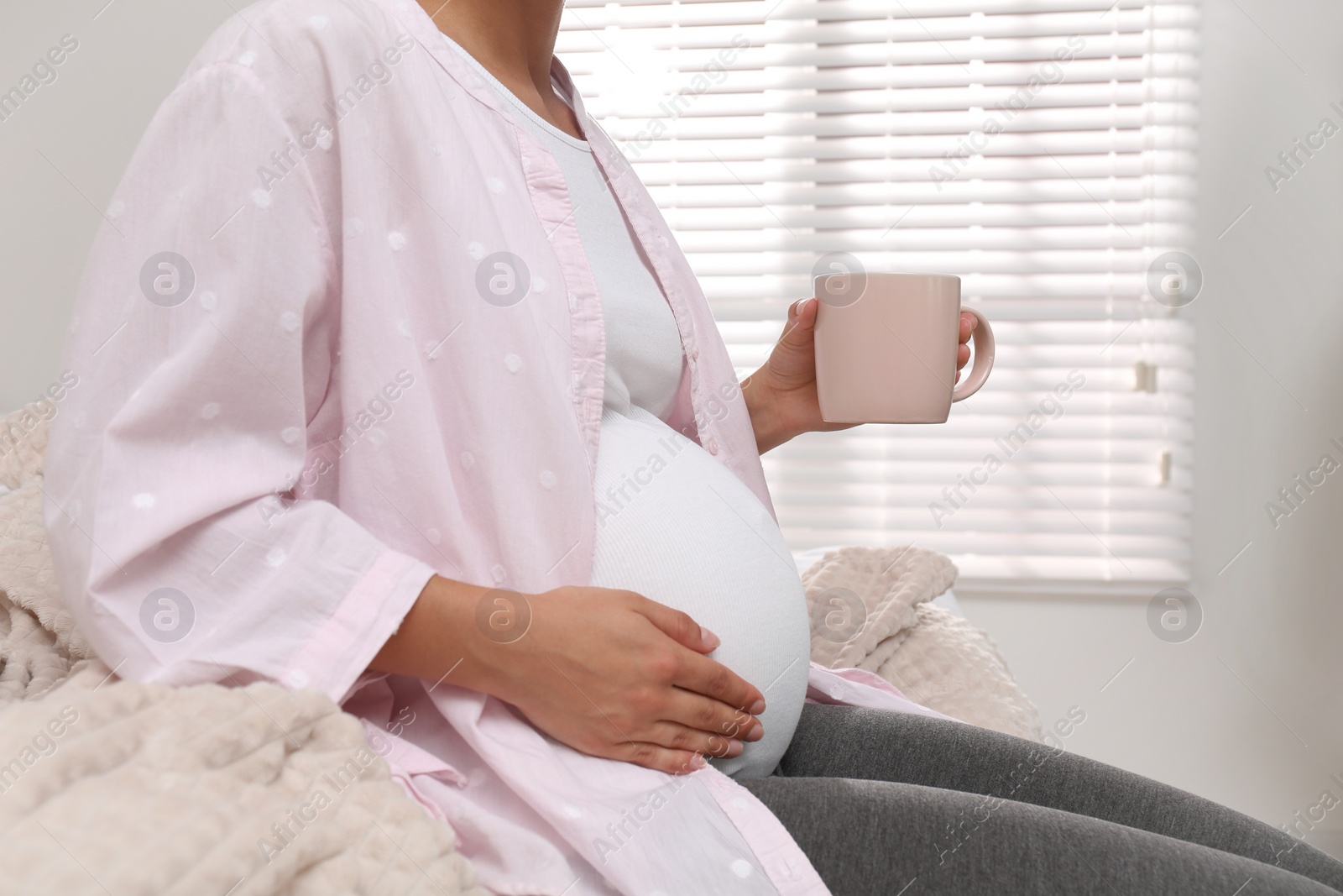 Photo of Pregnant woman drinking tea at home, closeup