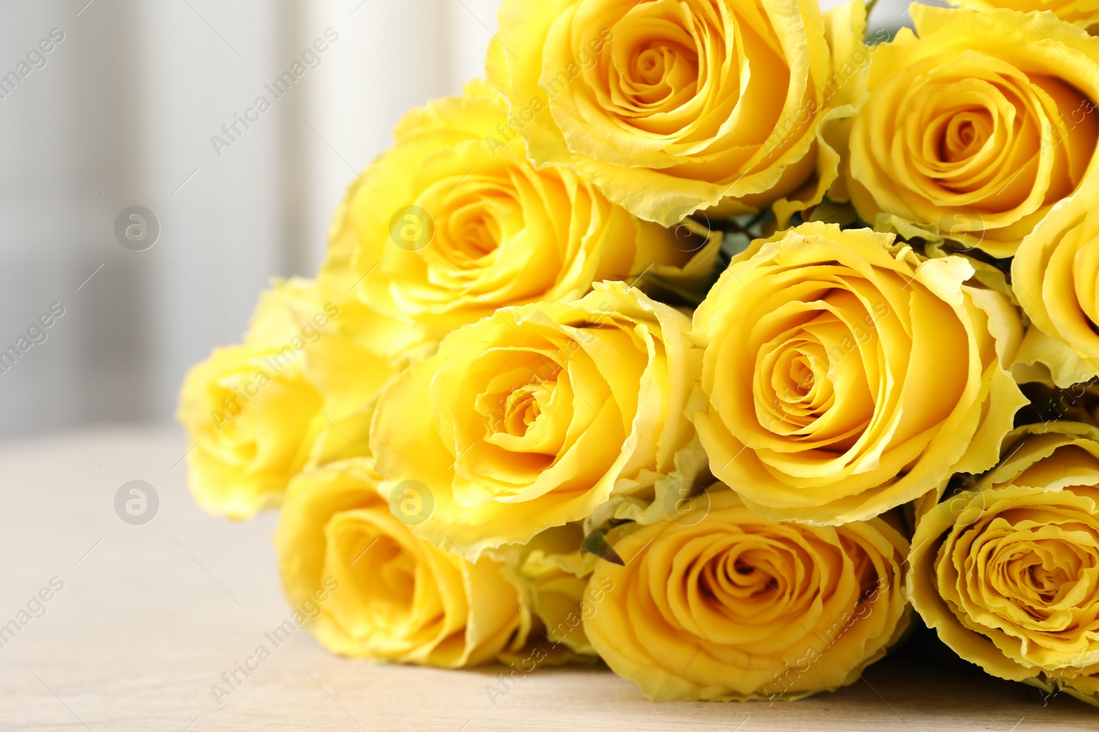 Photo of Beautiful bouquet of yellow roses on table, closeup