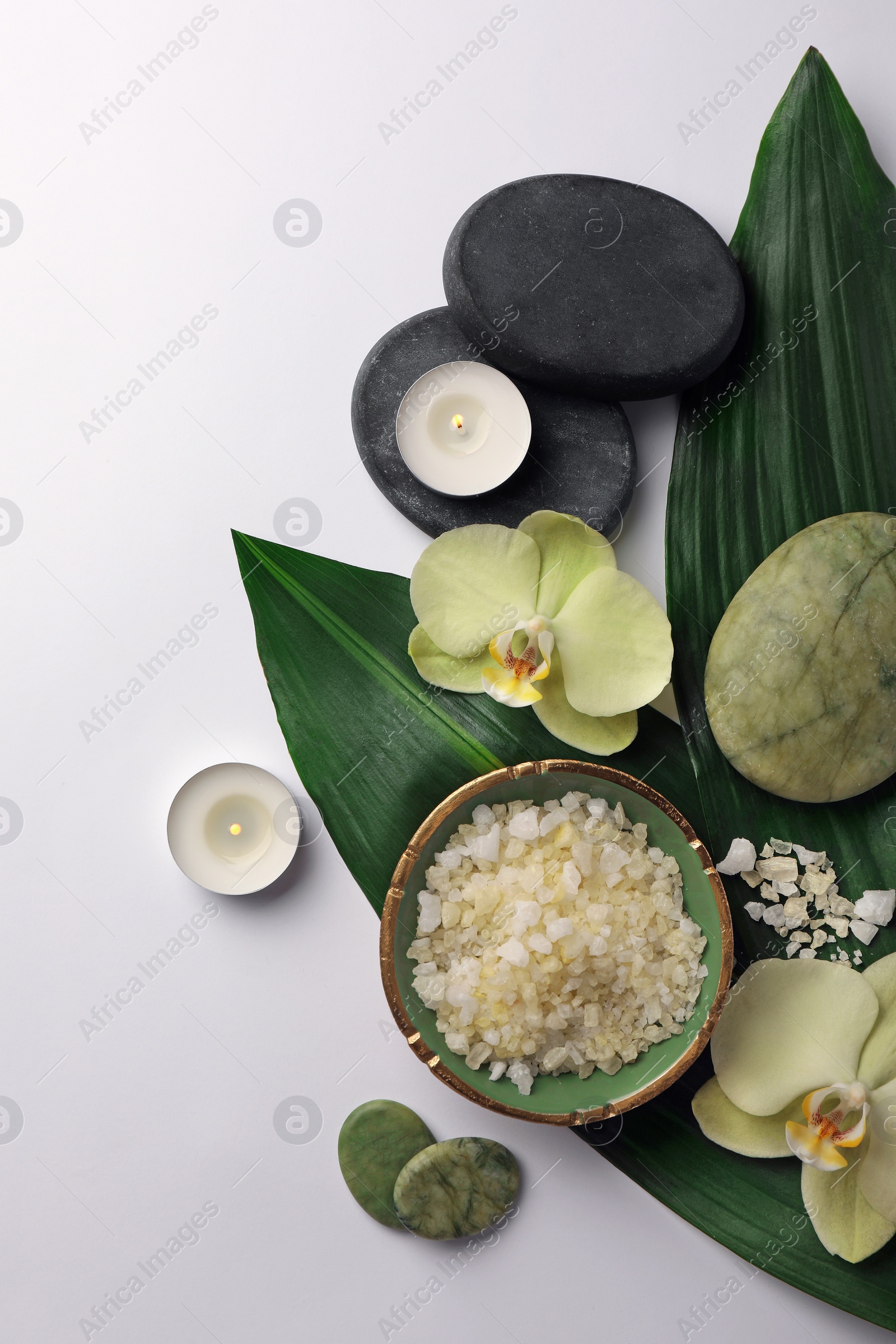 Photo of Flat lay composition with spa stones, sea salt and beautiful flowers on white table. Space for text