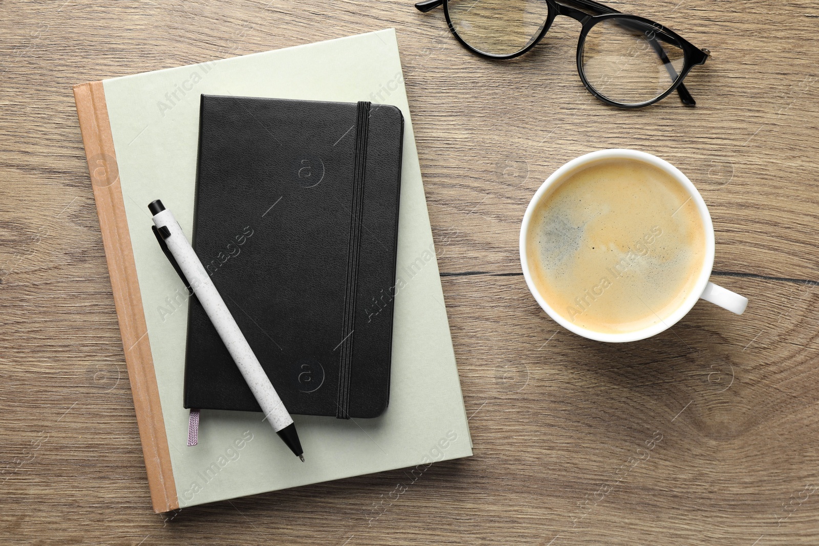 Photo of Flat lay composition with notebooks and coffee on wooden table