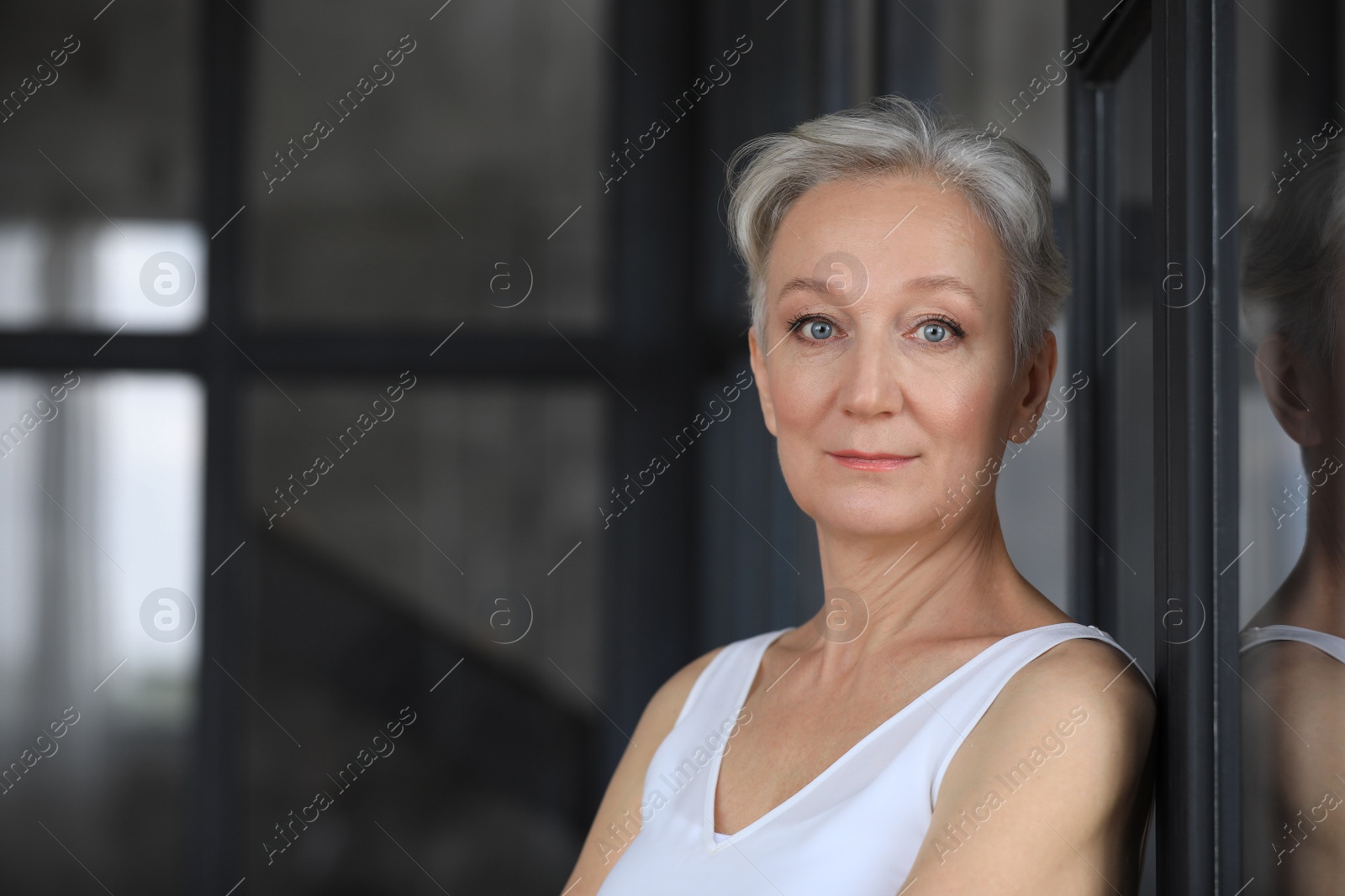 Photo of Portrait of happy mature woman indoors, space for text. Smart aging