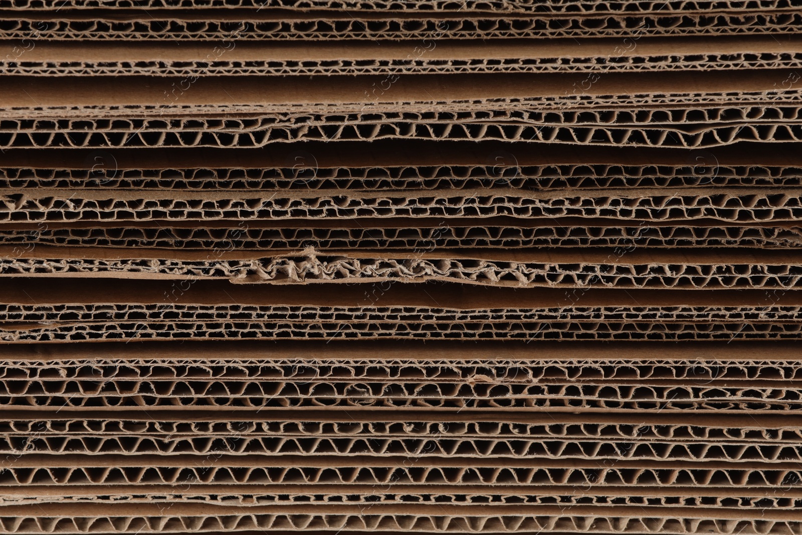 Photo of Sheets of brown corrugated cardboard as background, closeup