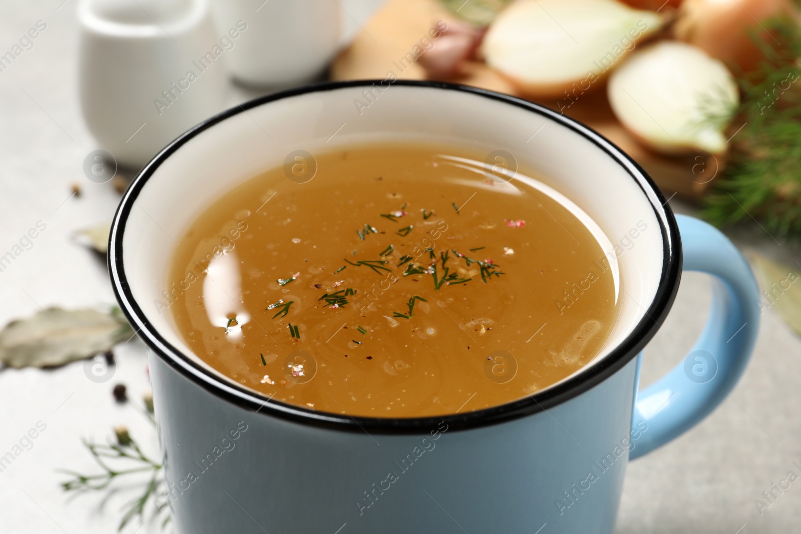 Photo of Hot delicious bouillon with dill in cup, closeup