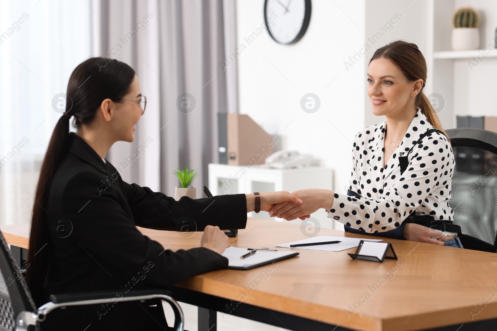 Photo of Lawyer shaking hands with injured client in office