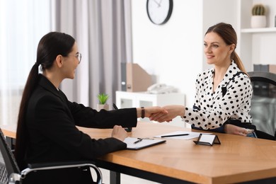 Lawyer shaking hands with injured client in office