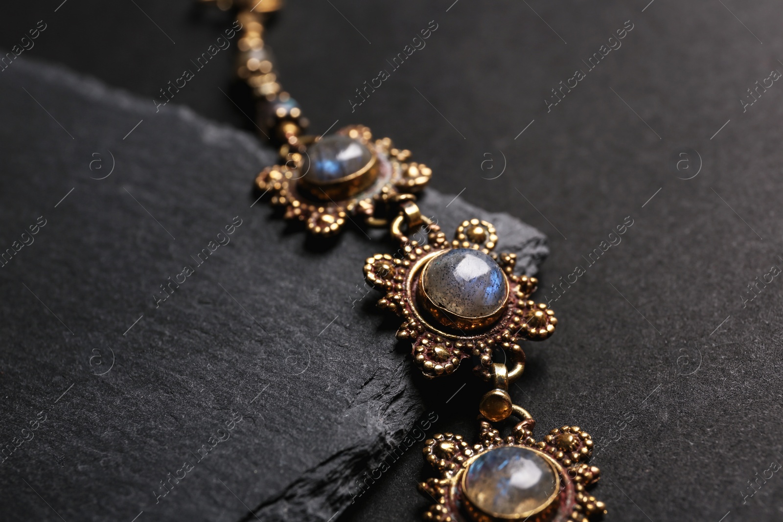 Photo of Elegant bracelet on black background, closeup. Luxury jewelry