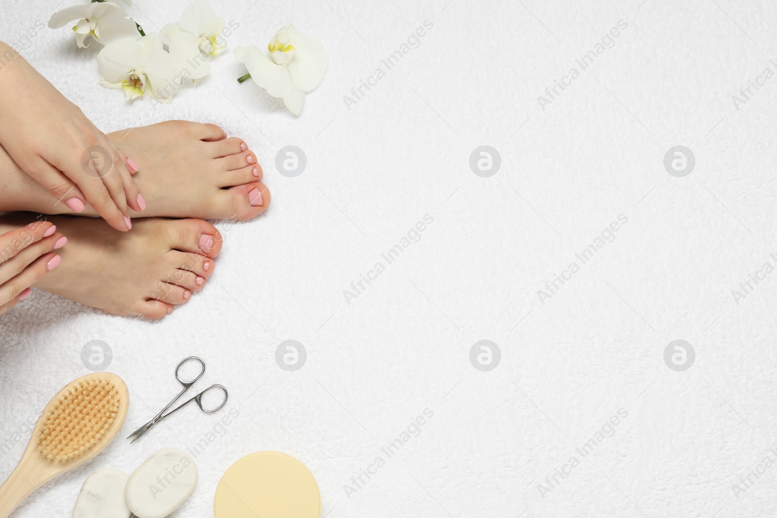 Photo of Closeup of woman with neat toenails after pedicure procedure on white terry towel, top view. Space for text