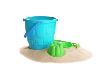 Set of plastic beach toys and pile of sand on white background