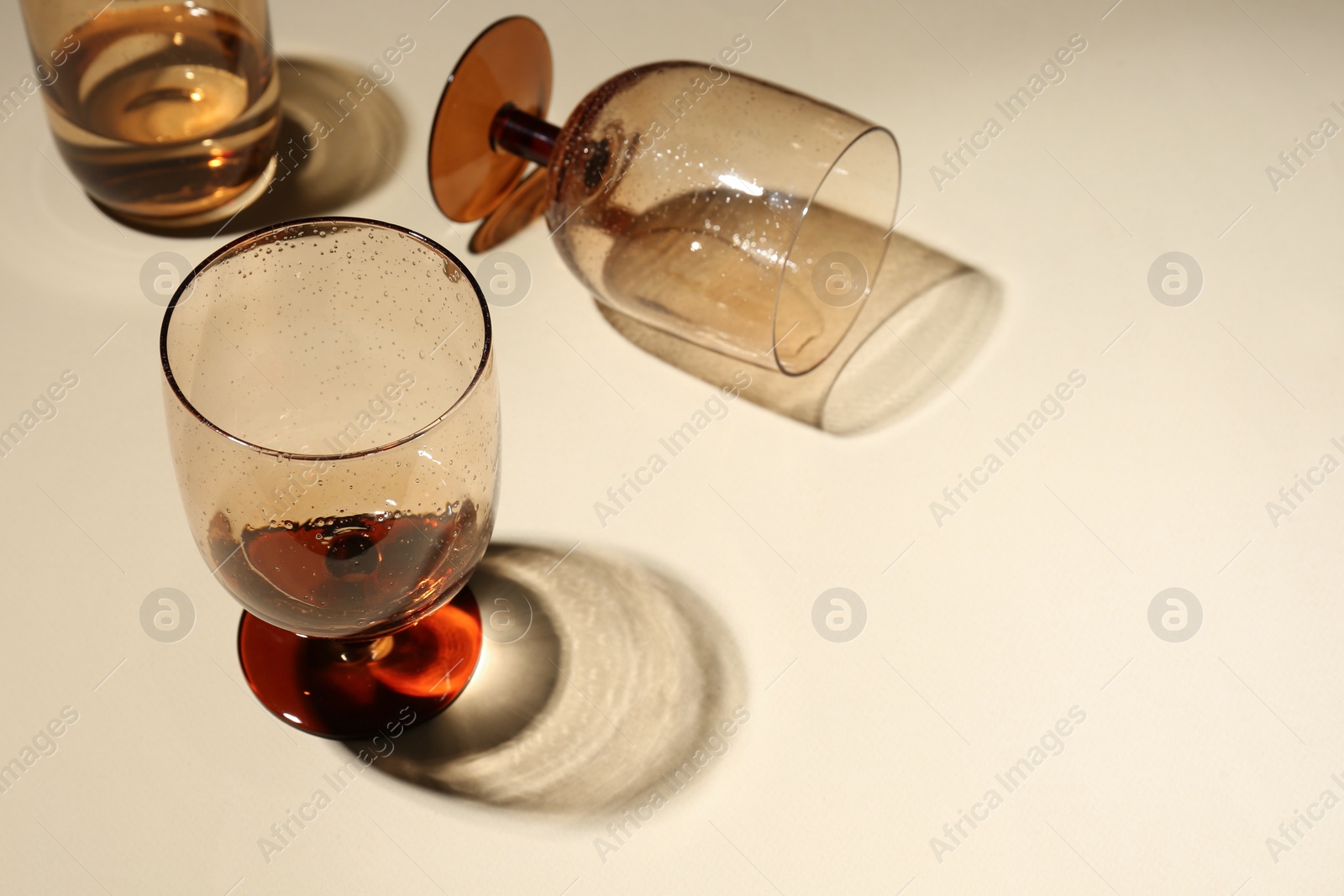 Photo of Glasses with drinks on beige background, space for text