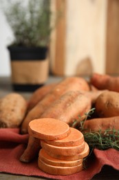 Photo of Napkin with thyme and sweet potatoes on table