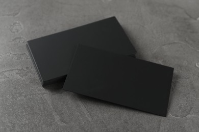 Photo of Blank black business cards on grey table. Mockup for design