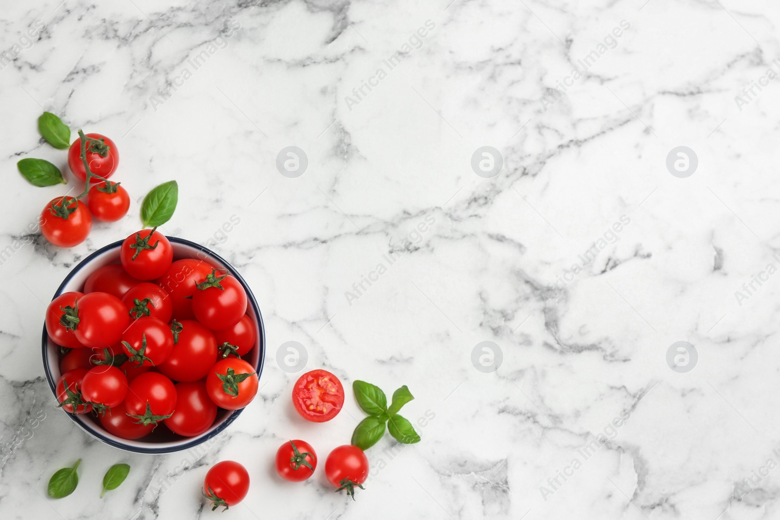 Photo of Flat lay composition with fresh cherry tomatoes and basil leaves on white marble table. Space for text