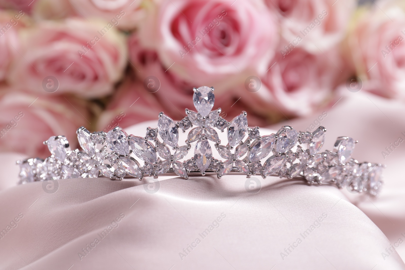 Photo of Beautiful silver tiara with diamonds on pink silk cloth