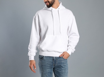 Photo of Young man in sweater on grey background, closeup. Mock up for design