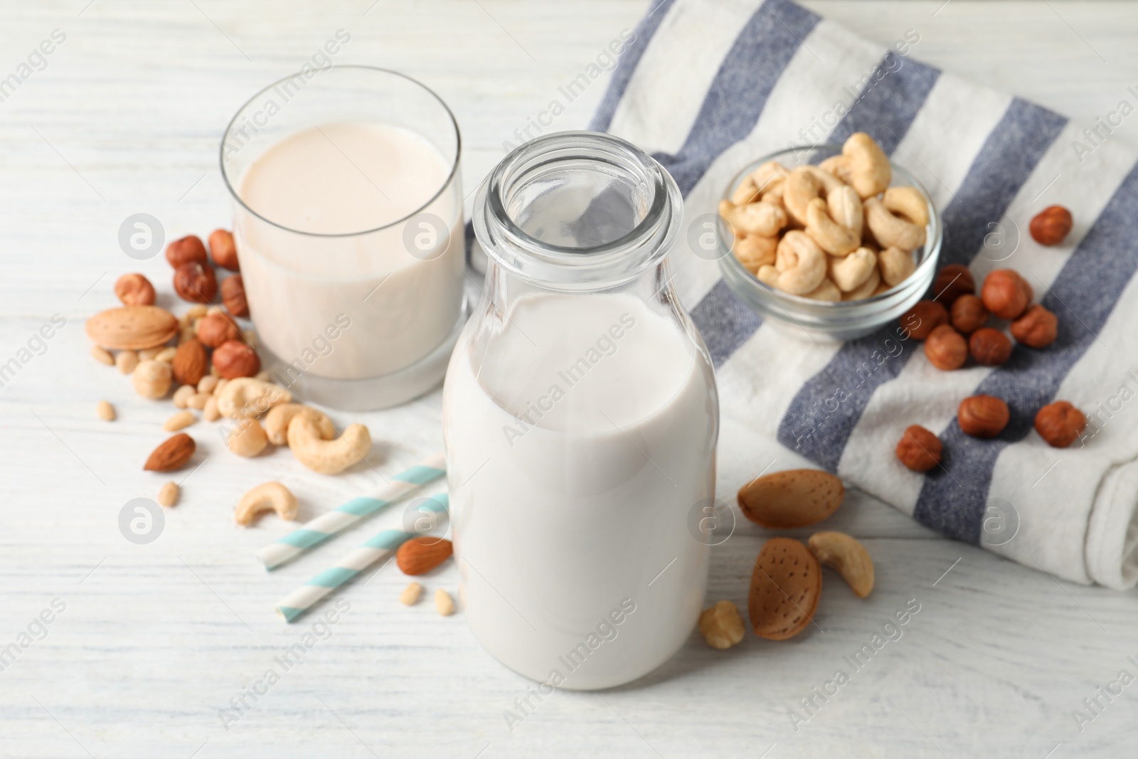 Photo of Different nut milks on white wooden table