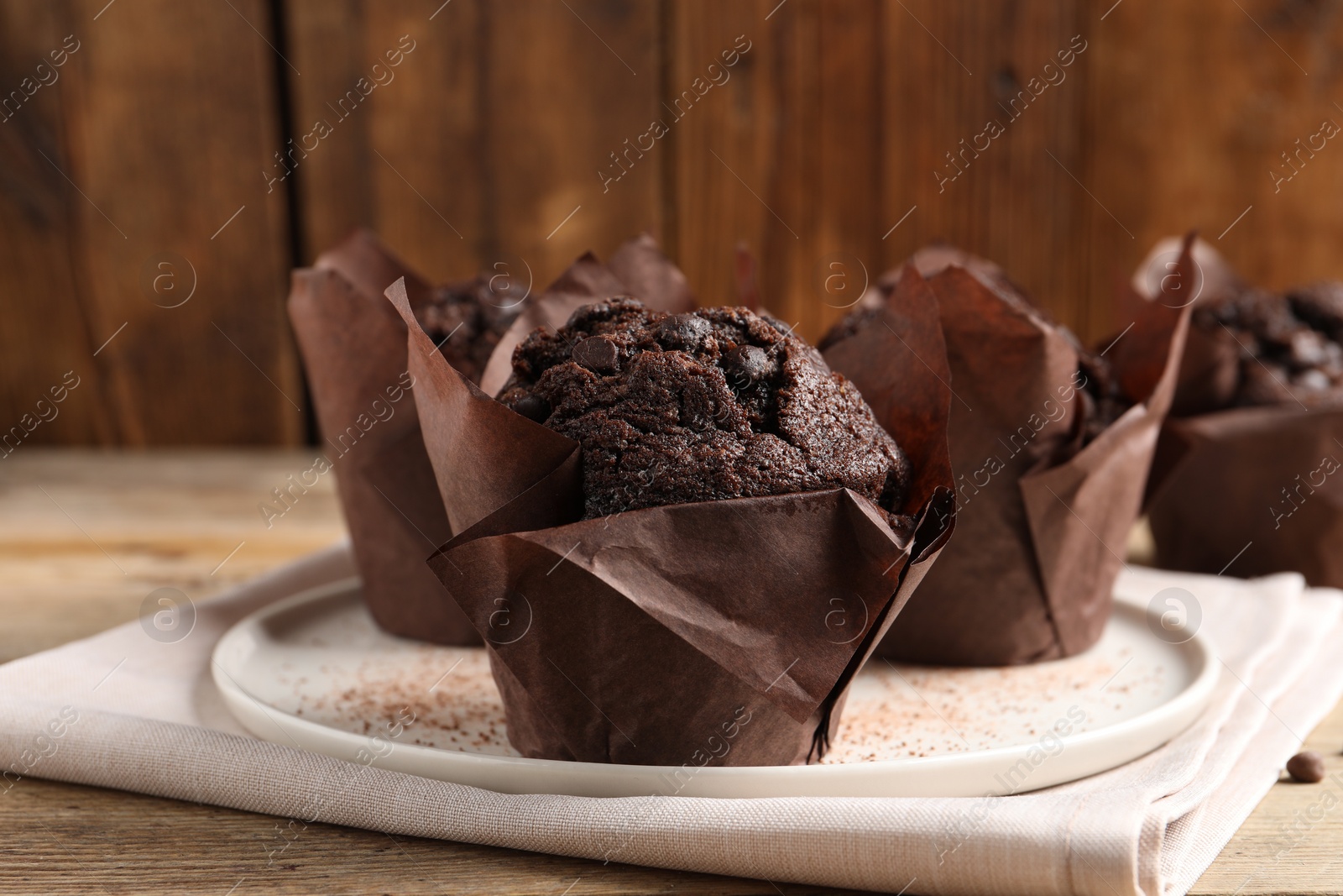 Photo of Tasty chocolate muffins on wooden table, closeup