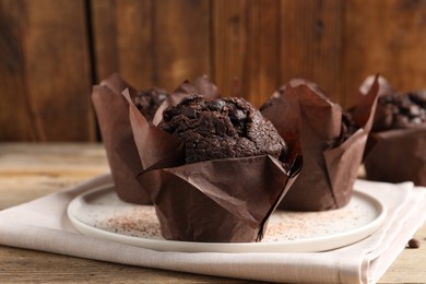 Photo of Tasty chocolate muffins on wooden table, closeup